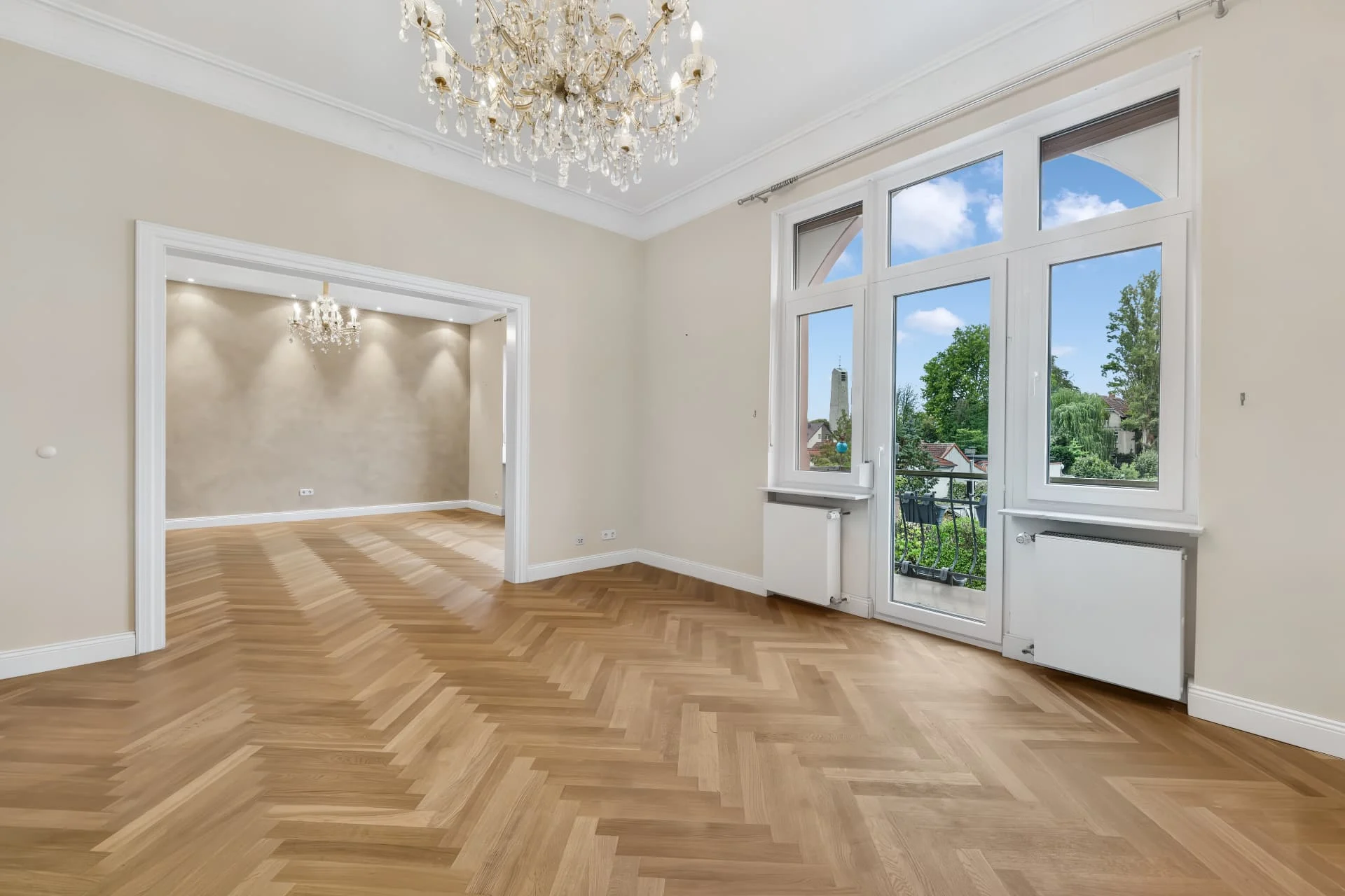 Lichtdurchfluteter Altbauraum mit Parkett und hohen Fenstern