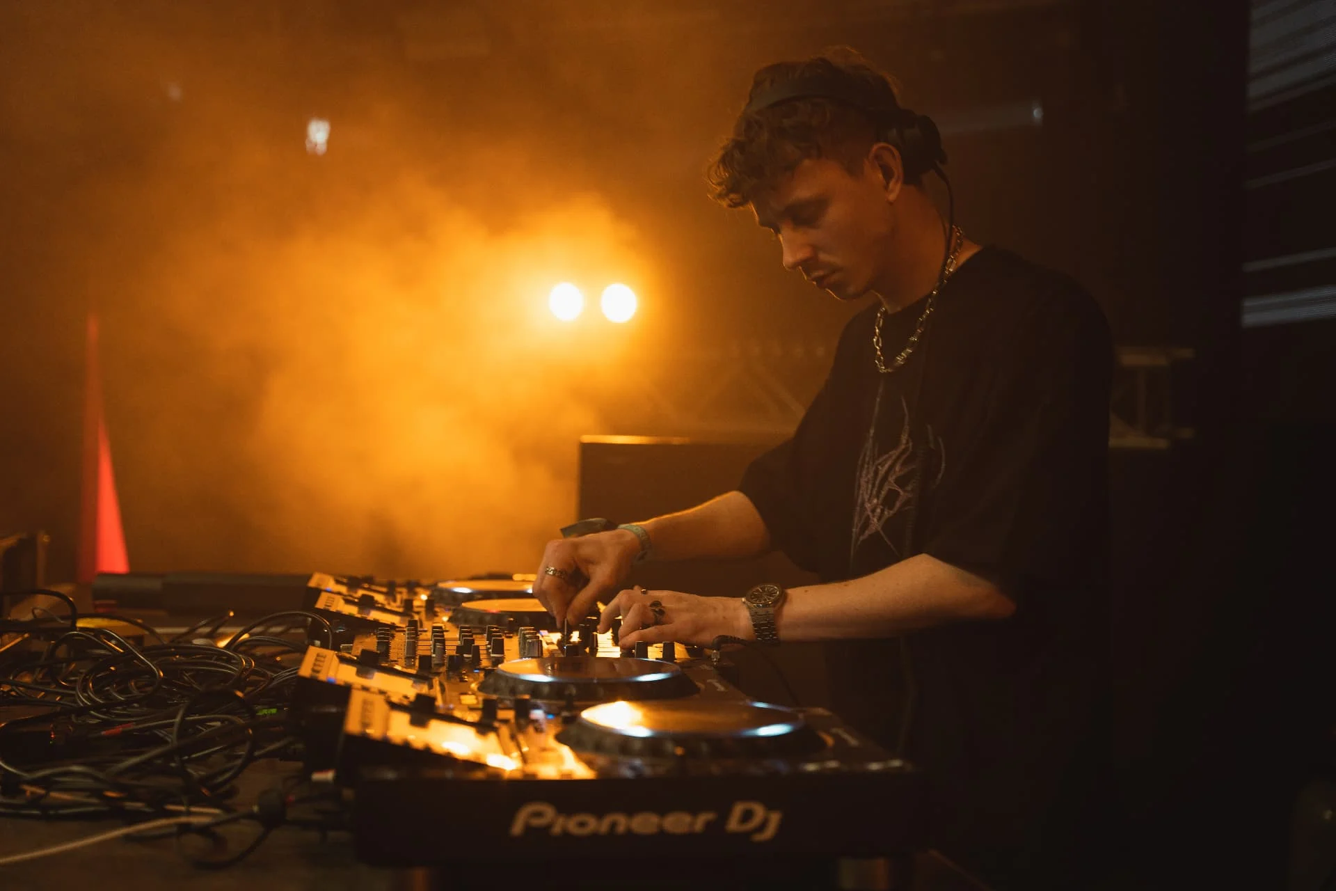 DJ am Mischpult im warmen Bühnenlicht